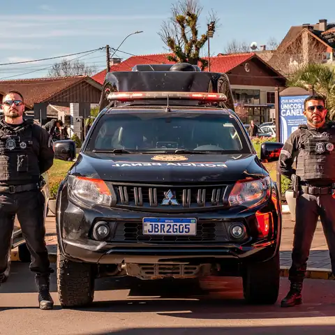 Agentes da Polícia Civil ao lado de viatura durante ação conjunta das forças de segurança em Canela.